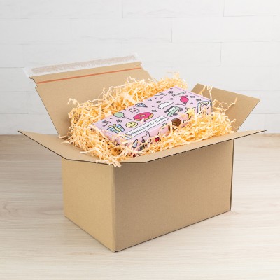 Otwarty karton e-commerce z paskiem klejowym z wypełniaczem papierowym.